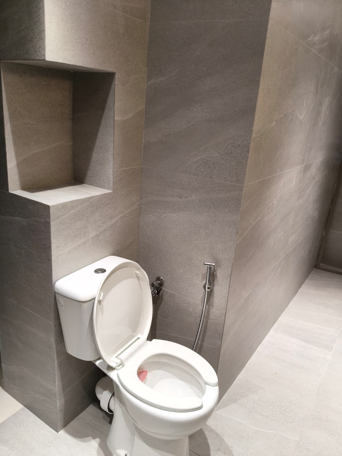 חדר רחצה בגווני אפור עם נישה ושירותים